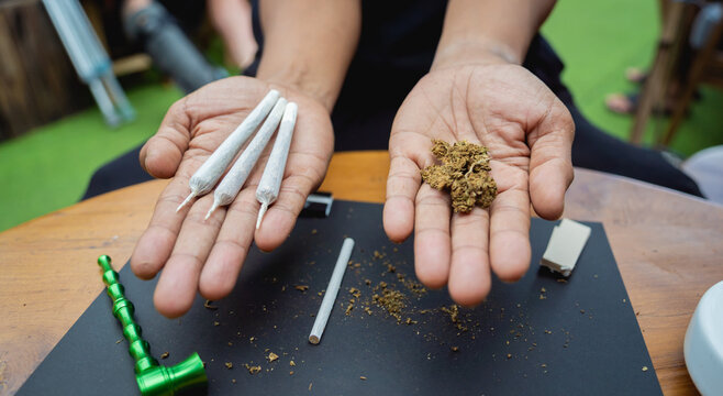 Young man making cigarettes with medical marijuana