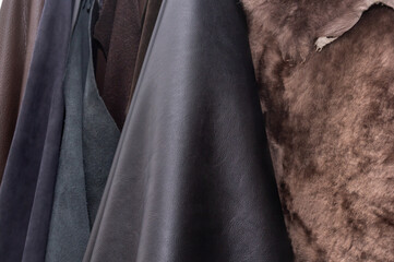 Blanks made of genuine leather, suede and fur for the repair and manufacture of shoes on the shelves of a shoemaker's shop. Close-up