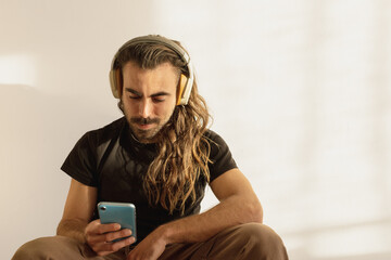 long-haired man listening to music, watching a video