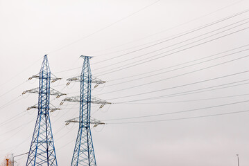 Blue high Pylon high-voltage power lines, high voltage electric transmission tower for producing electricity at high voltage electricity poles at the sunset.