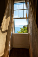 Summer breeze moving curtains of the window with stunning view on the Adriatic sea and mountains at...