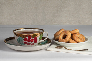 a cup of tea with cookies on the table with a white tablecloth
