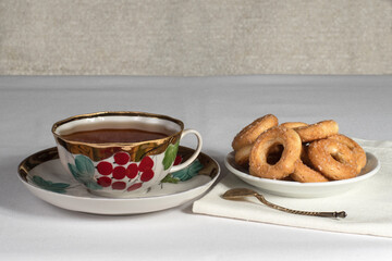 a cup of tea with cookies on the table with a white tablecloth