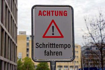 Warning traffic sign with text Achtung Schritttempo fahren, translation is attention drive walking pace at City of Zürich on a cloudy winter noon. Photo taken December 20th, 2022, Zurich, Switzerland.