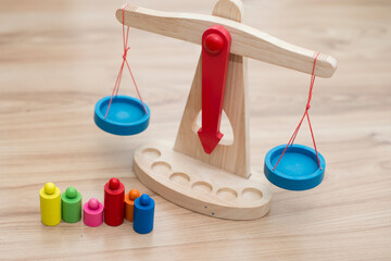 Scales of justice. Wooden ancient style swinging scales with colorful weights. Children toy for...