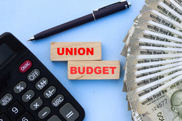 word union budget on wooden cube with Indian currency and calculator