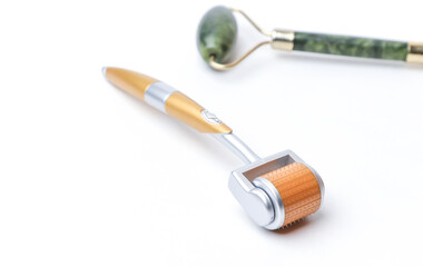 Two different massage rollers for face on white background. Selfcare, skincare concept. 
