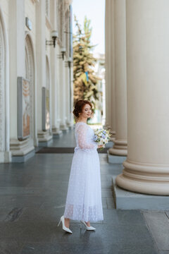 portrait of a young bride girl in a light dress in an urban environment