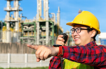 engineer manager wear safety helmet uniform talk with engineer team with radio walkie talkie during work with refinery, petrochemical, petroleum in chemical plant business background