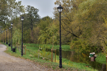 Autumn alley with old-fashioned lanterns in autumn colors on a slightly cloudy day. autumn.