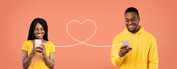 Young black couple sending love messages to each other via smartphones