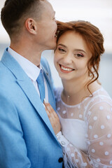 bride in a light wedding dress to the groom in a blue suit