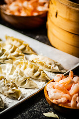 Homemade raw dumplings gyoza with shrimp on a baking sheet. 