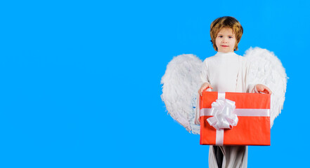 Valentines day. Little angel in wings with Valentine present. Cupid boy with gift box. February 14.
