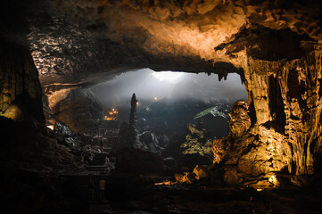 large foggy illuminated underground cave in limestone rock in vietnam
