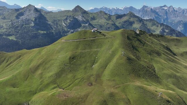 Fronalpstock cable car lift offers an aerial perspective of the Swiss Alps in the summer, providing panoramic views of the mountain summit, nature, wildlife, and culture. Aerial view.
