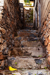 Old rock staircase with city view on background. Narrow stairway in the town. Selective focus. Blurred background.