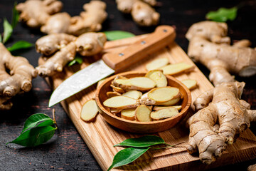 Chopped ginger on a cutting board with a knife. 
