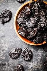 Prunes in a wooden plate on the table. 