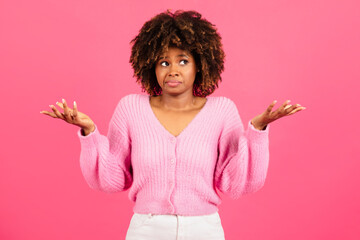 Insecure confused incompetent millennial african american curly lady in casual spreads her arms to...