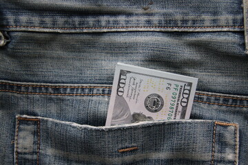 Dollar bills in a back pocket of jeans.