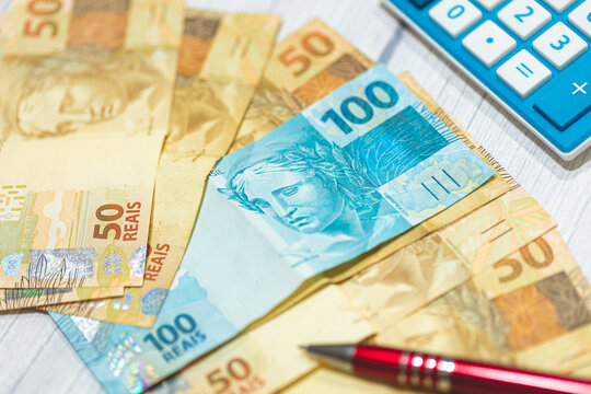 Notas do Real Brasileiro sobre uma mesa de madeira. Economia brasileira, finan&ccedil;as e a infla&ccedil;&atilde;o. Dinheiro, Brasil.