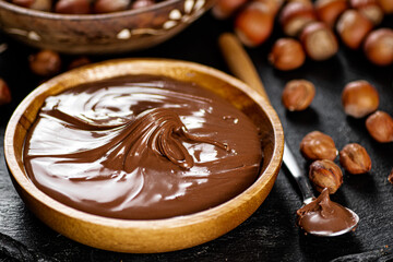 Hazelnut butter on a stone board on a plate and in a spoon. 