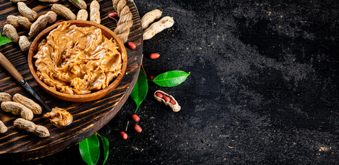 Peanut butter on a wooden tray with leaves. 