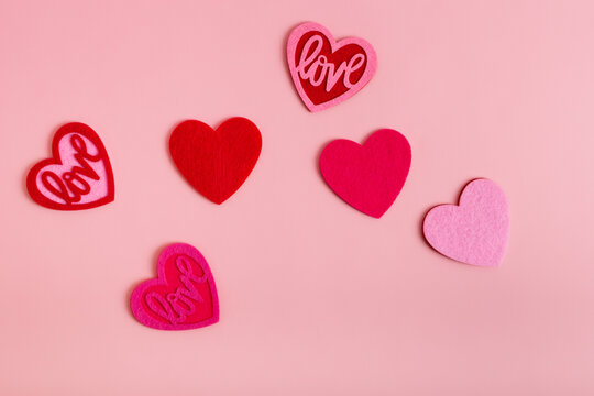 Romantic pictures for Valentine's Day with red and pink colored hearts from above on pink light background. 