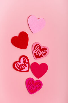 Romantic pictures for Valentine's Day with red and pink colored hearts from above on pink light background. 