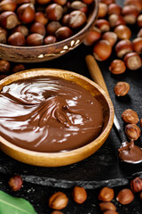 Hazelnut butter on a stone board on a plate and in a spoon. 