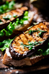 Delicious grilled eggplant sandwich. On a wooden background.