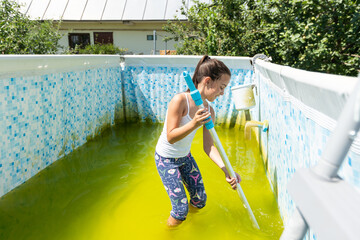 a little girl cleans a very dirty pool