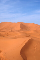 Fototapeta na wymiar A quiet desert that is slightly undulating. The sand has orange tones.