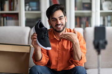 Handsome arab guy fashion blogger showing brand new shoes