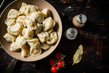Dumplings on a cutting board with cherry tomatoes. 