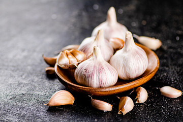 Fresh garlic on a wooden plate. 