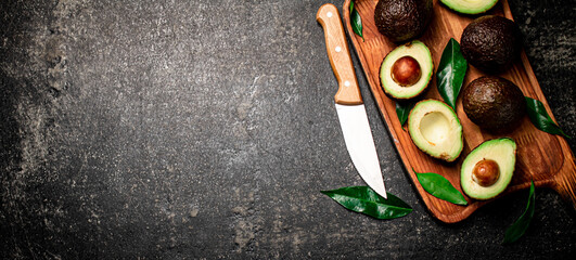 Fototapeta na wymiar Fresh avocado with foliage on a cutting board.