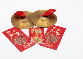 Chinese New Year red envelopes with gold letters and gold cymbals with red ribbons. - Powered by Adobe