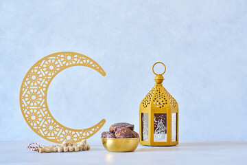 Ramadan kareem background . Golden Ramadan half moon decor with lantern, Islamic rosary beads and dates fruit.