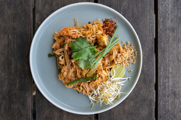 Top down view of a vegetarian pad thai dish (Thai stir fried noodles) on a blue plate