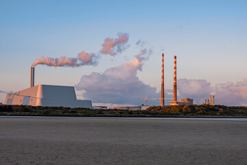 Poolbeg chimneys at dusk, power plants emitting fumes, electricity production, Dublin, Ireland
