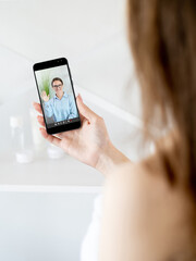 Video talk. Virtual chat. Morning teleconference. Distant communication. Female friends speaking online on phone screen at light home interior.