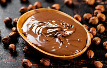 Hazelnut butter with peeled hazelnuts on the table. 