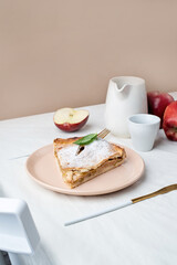 Homemade piece of apple pie with fresh red apples on white table