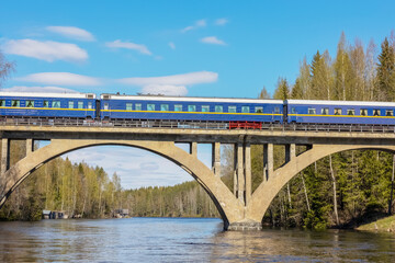 passenger train on a high old railway bridge over the river - Powered by Adobe