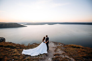 Full length view of the happy wedding couple on the edge of the world
