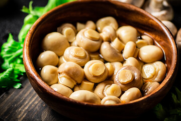 Delicious pickled mushrooms on a cutting board. 