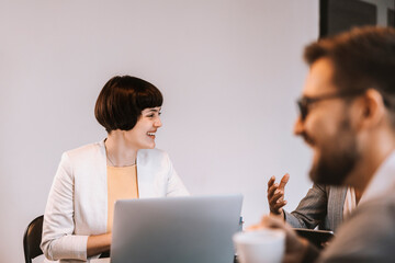 A happy mentee is sitting with mentors at the boardroom and discussing about project.