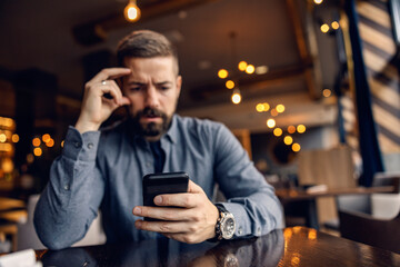 Selective focus on hand with phone. A man is reading message on the phone.